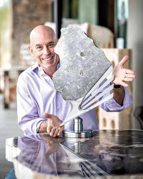 Rare Earth Gallery owner Wayne Helfand with a meteorite slice on a custom stand