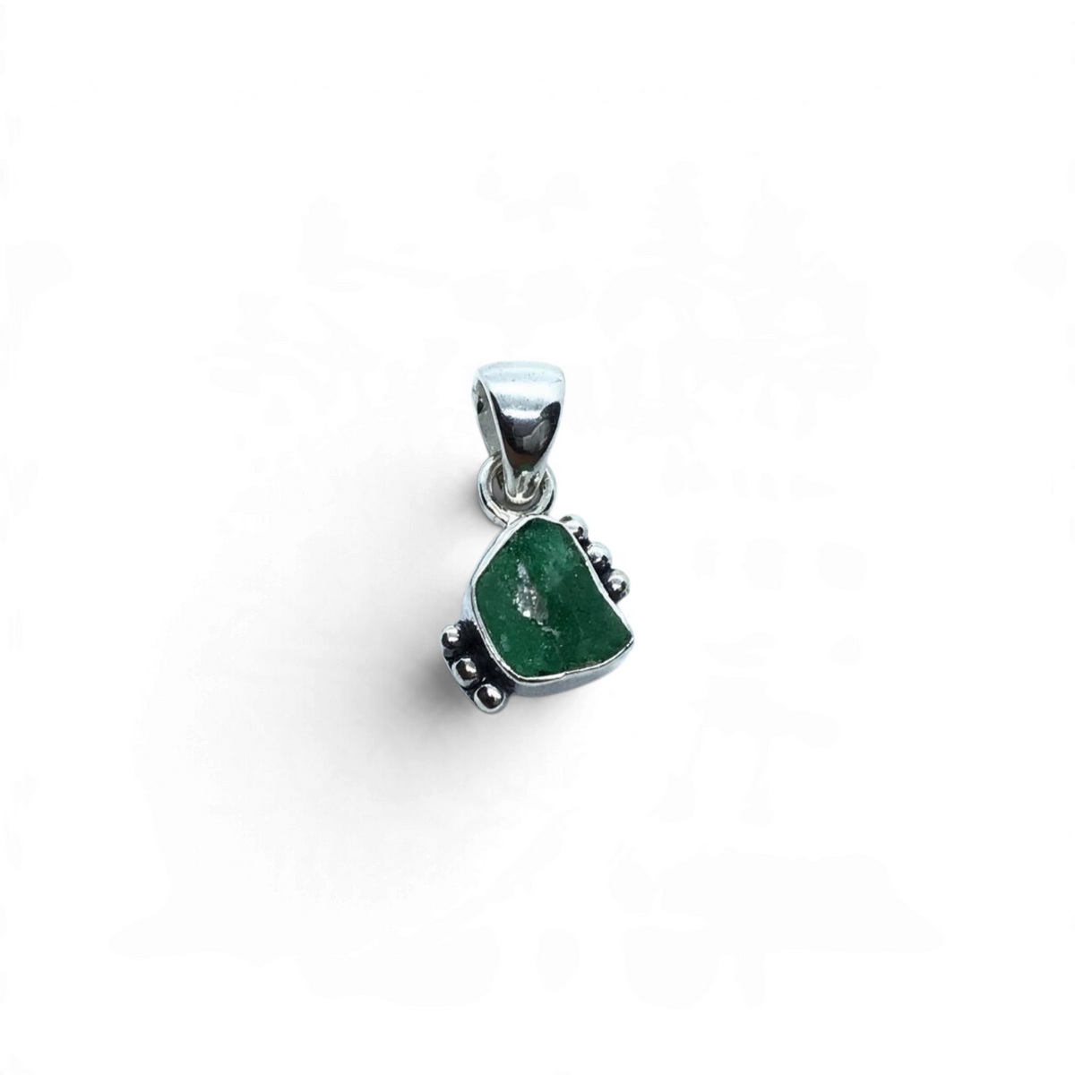 Rare Earth Gallery rough freeform emerald pendant set in a 925 sterling silver bezel with decorative side beading.
