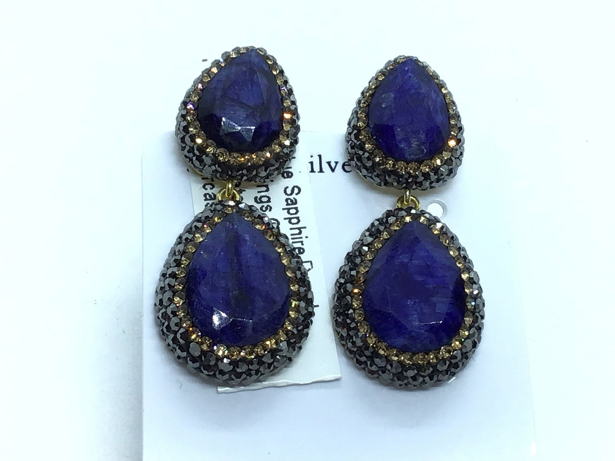 Pair of blue sapphire two-tier pear dangle earrings on a display card with marcasite trim
