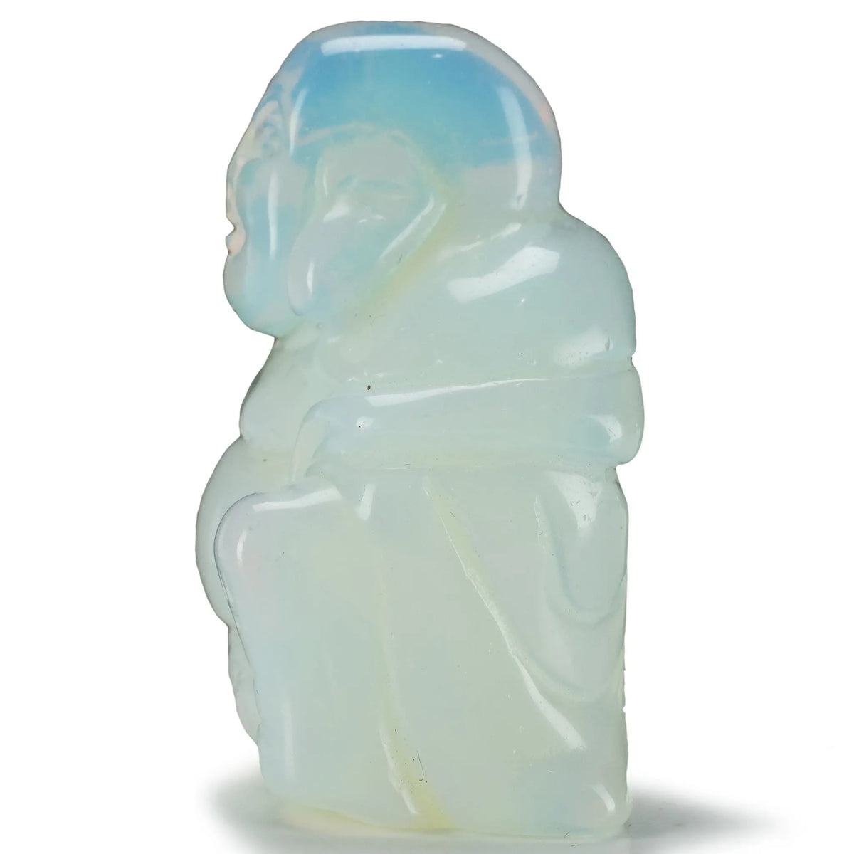Side profile of the carved Opalite Buddha showing draped robe folds and a blue tinted translucent crown