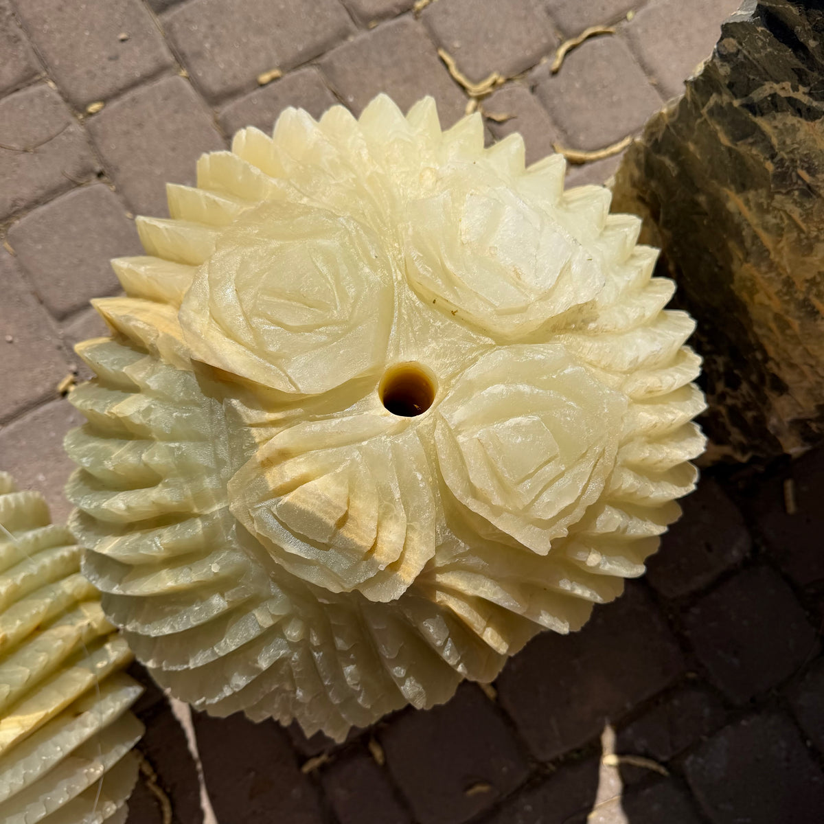Four carved rose blooms and spiked ribs crowning the barrel cactus onyx fountain