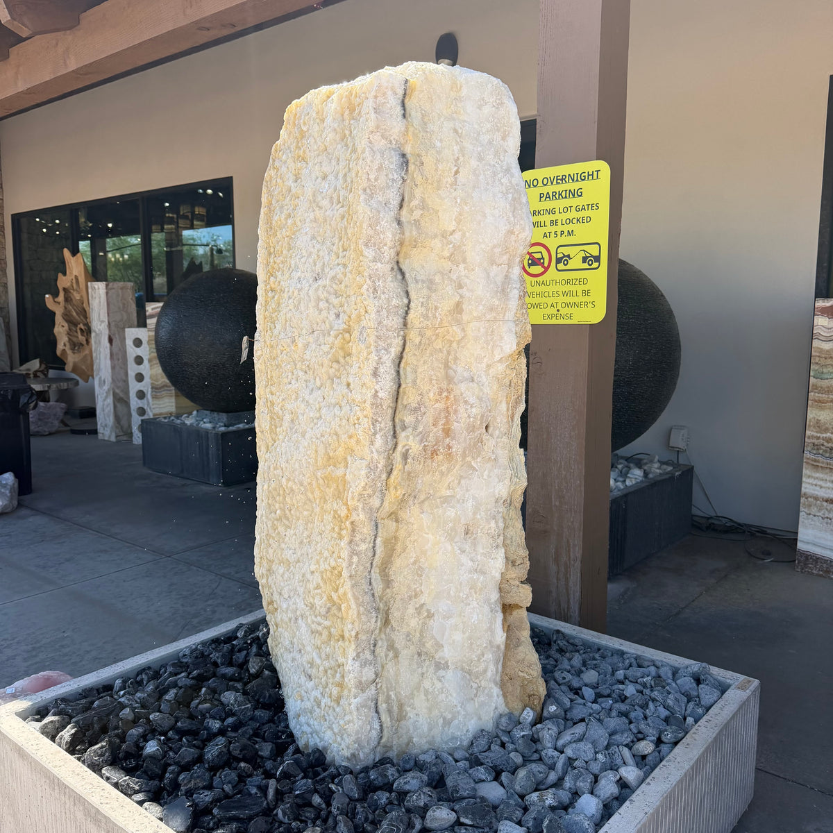 White crystal and gray onyx band fountain with a dark band down the crystal face, in a black stone basin