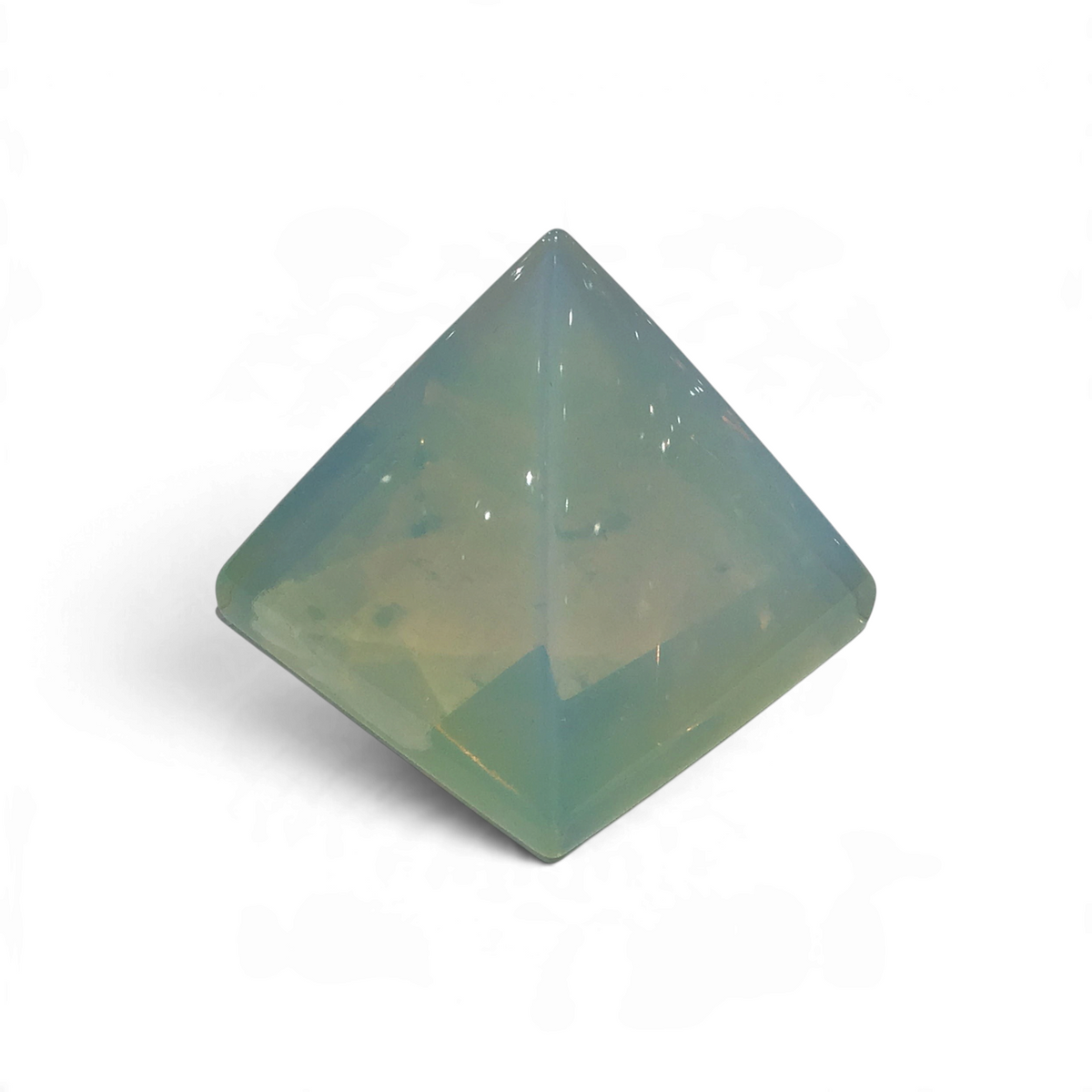 Translucent opalite pyramid with a milky blue-green glow, viewed from above on a white surface