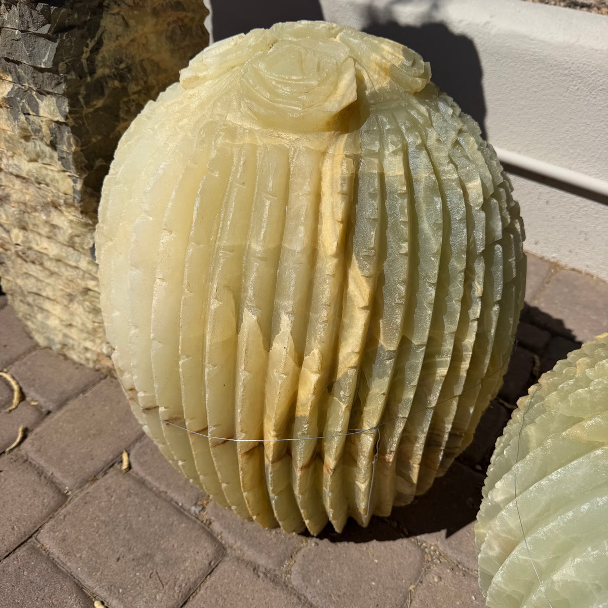 Rounded ribbed onyx cactus fountain with a single rose bloom at the crown