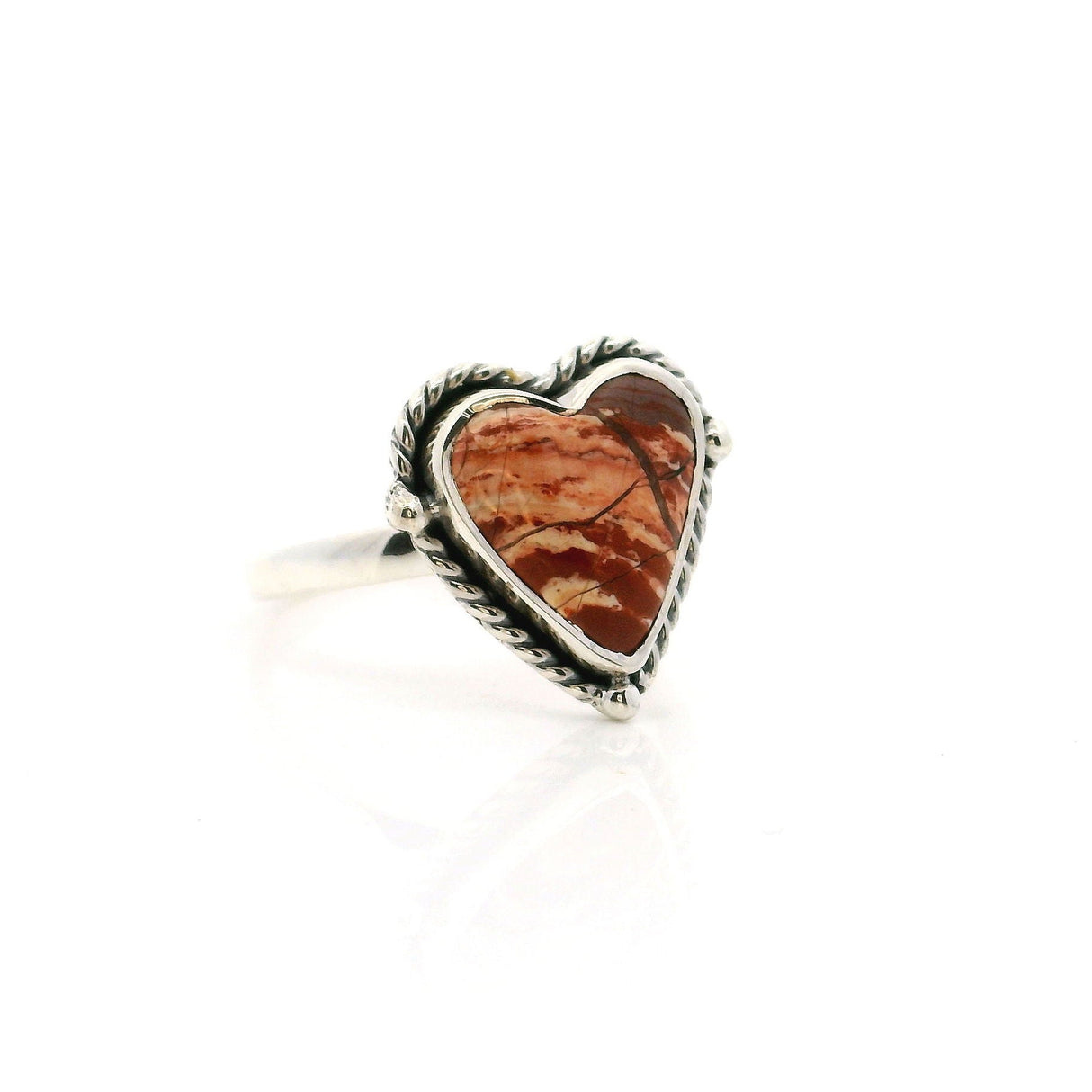 Heart-shaped jasper ring with silver band on a white background