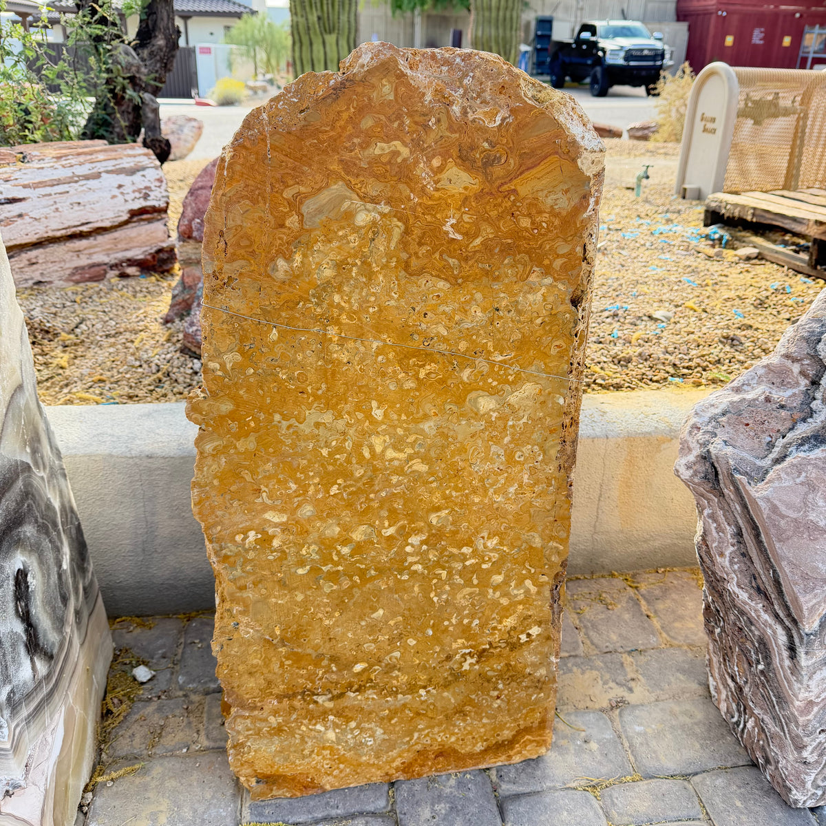 Green gray onyx gold travertine fountain standing upright, honey-gold cosmic swirl face, outdoor stone yard