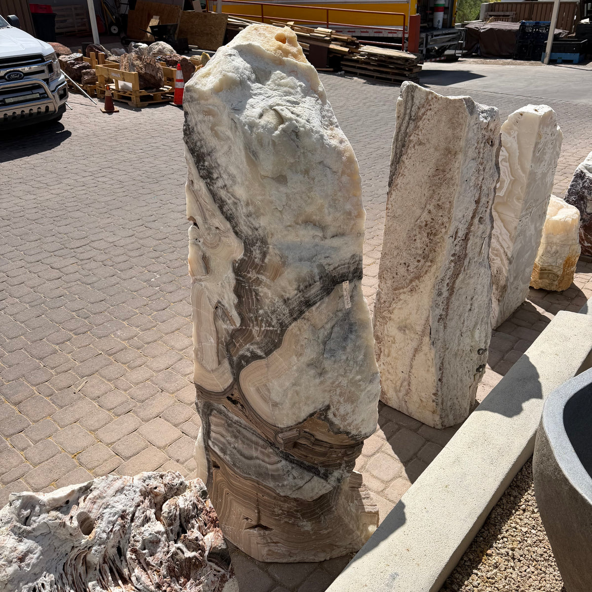 Sunlit Cosmic Orange Zebra Onyx fountain column showing crystalline white top and dark diagonal veining