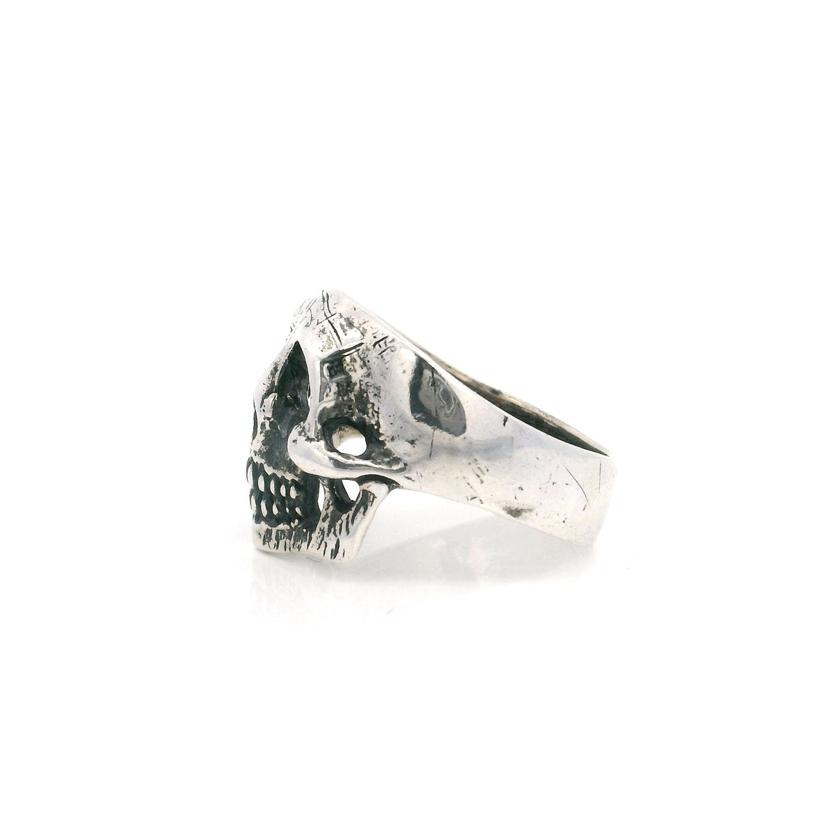 Sterling silver skull ring shown in side profile with a worn oxidized finish