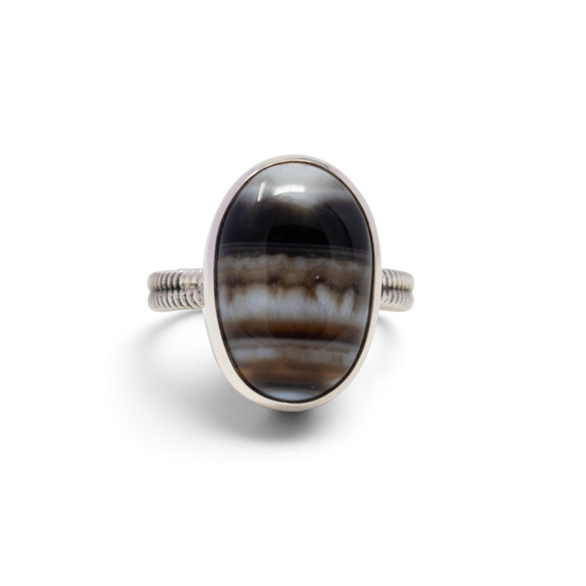 Banded agate ring, oval cabochon with black, brown and white bands in a silver step bezel, front view