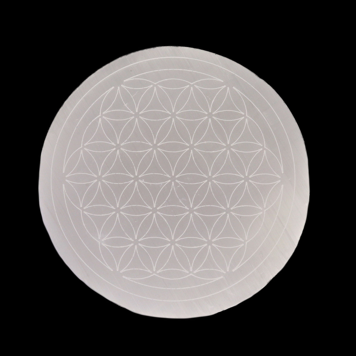 White selenite disc, engraved with Flower of Life sacred geometry, top-down view