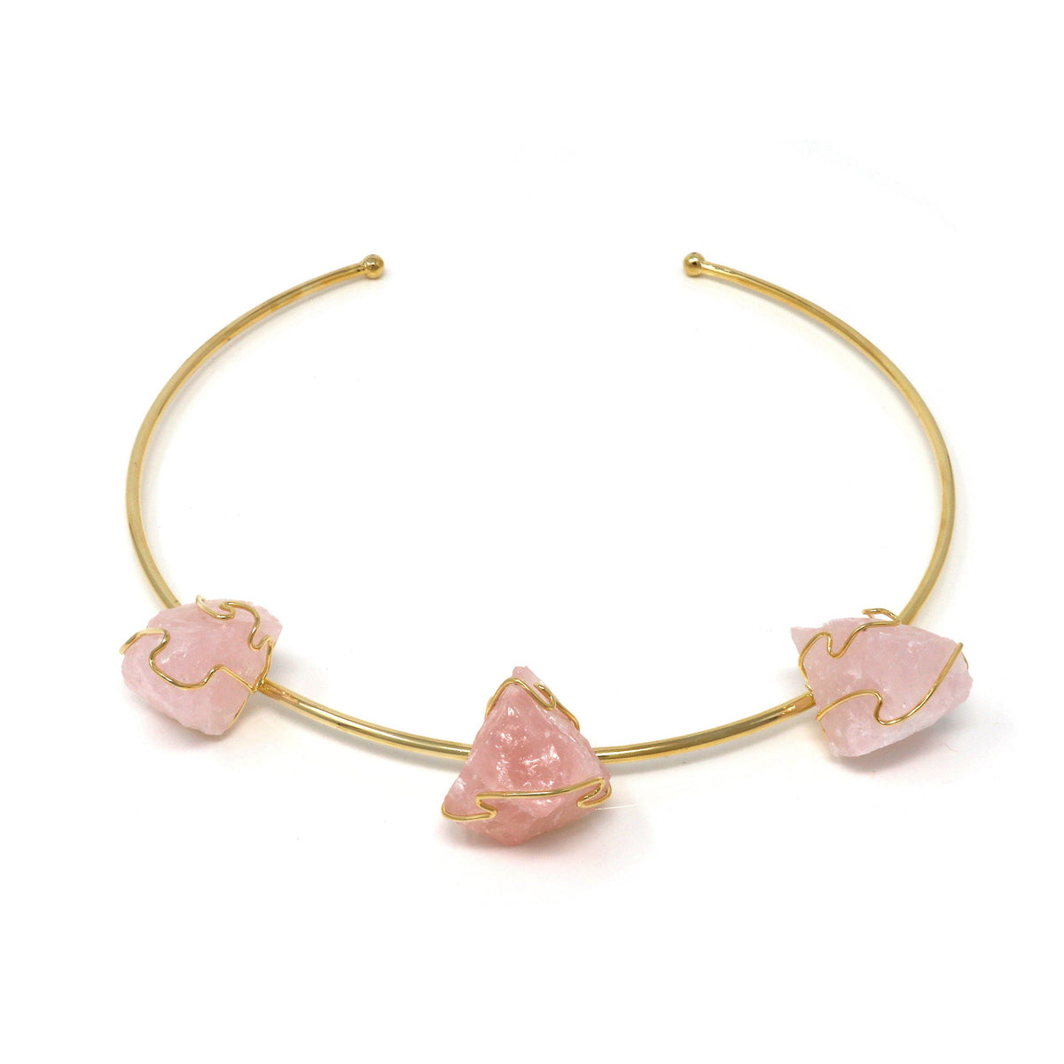 Gold wire-wrap collar necklace with three raw rose quartz gems, angled flat-lay on white