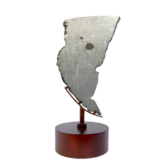 Genuine meteorite slice on a wooden base with a white background