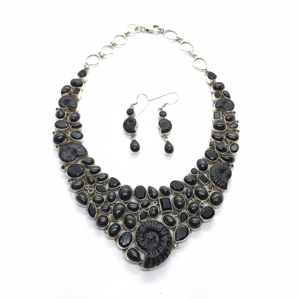 Rare Earth Gallery ammonite fossil necklace set with black spinel and black star garnet. Features spiral ammonites and mixed-cut black gemstones.