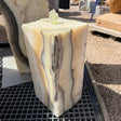 Zebra fossil onyx block fountain with water welling from the polished top and spilling down