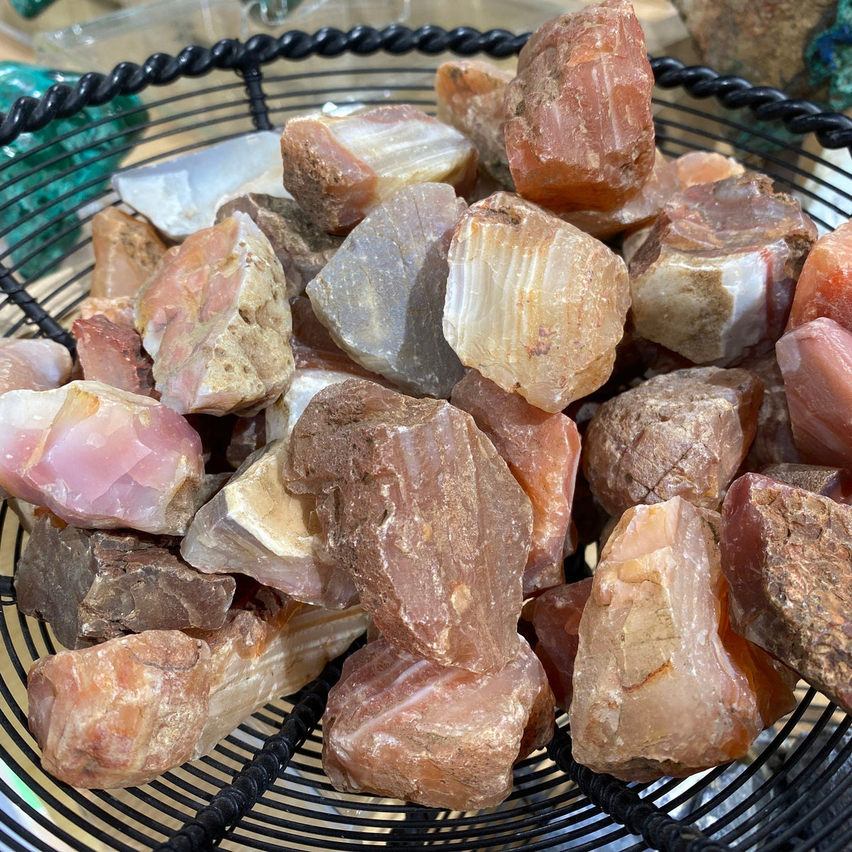 Basket of rough Madagascar carnelian geode pieces from the Waterline Mine in orange, pink and cream