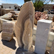 Cosmic Sunset Fossil Zebra Onyx pillar fountain with wavy caramel banding, beside a white marble pedestal