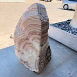Red Sunset onyx and travertine fountain with radial peach and rust banding and an organic rounded top