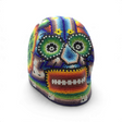 Huichol beaded skull with green flower motifs on either side and multicolor seed beadwork