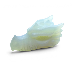 Opalite dragon skull carving in profile with milky white and yellow translucent glow