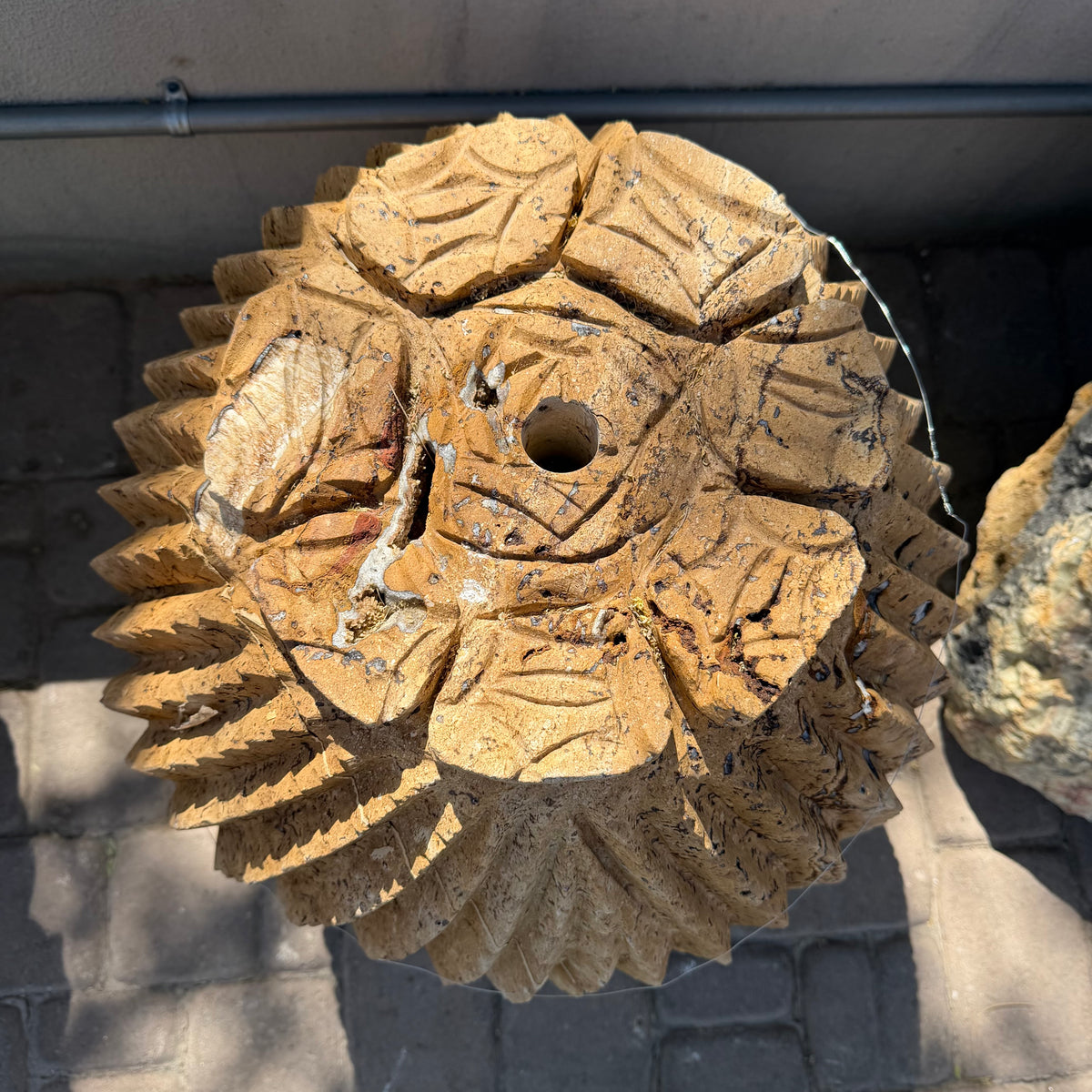 Overhead view of the carved leaf-tipped crown and drilled fountain hole on the travertine cactus