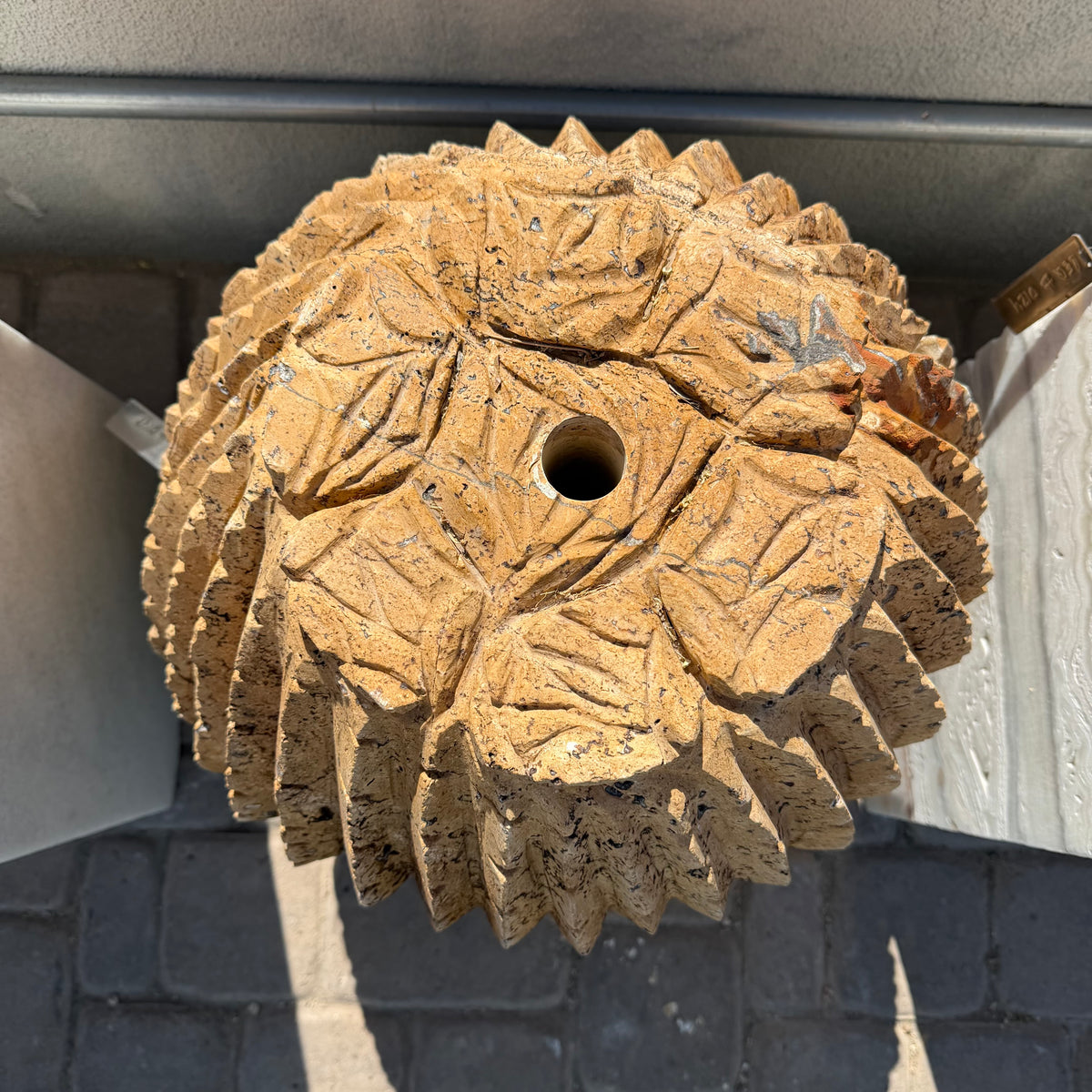 Spiky serrated rib tips and center drill hole seen from above, carving seated in its shipping box