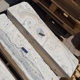 Overhead view of two zebra fossil onyx pillar fountains showing concentric orbital rings on the top faces