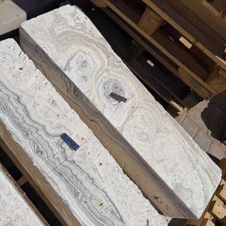 Overhead view of two zebra fossil onyx pillar fountains showing concentric orbital rings on the top faces