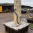 Cosmic onyx pillar fountain standing upright on a basin of white river stones in the gallery yard
