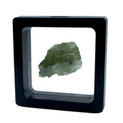 Flat rugged moldavite tektite nugget floating in a square black gel display frame