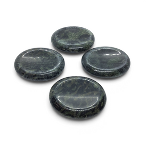 Four polished Kambaba Jasper palm stones with thumb divots, dark green and black, grouped on white