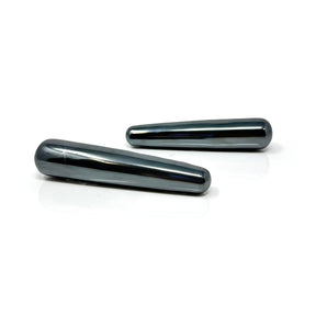 Two hematite massage wands with a polished metallic gray shine