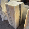Zebra Fossil Onyx block fountain with two dark vertical bands and a drilled top hole, set on brick pavers