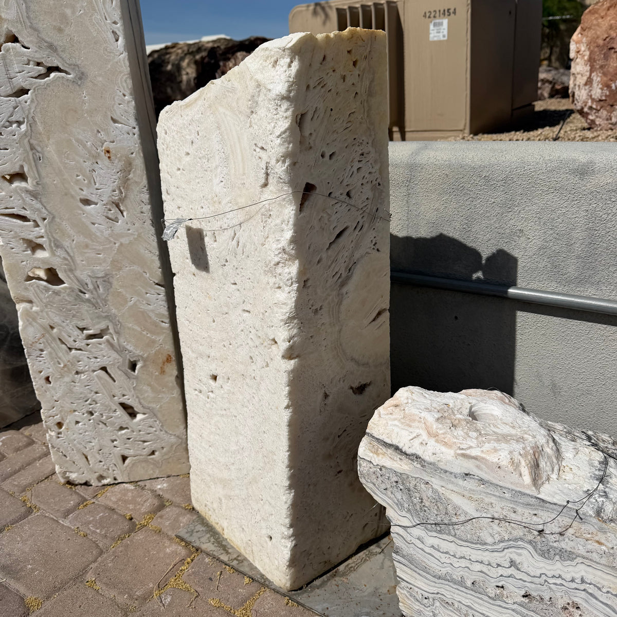 Side profile of the white fossil onyx rectangle column showing its slab thickness and pitted fossil texture