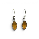 Rare Earth Gallery cognac amber dangle earrings featuring sharp oval cabochons set in 925 sterling silver bezels.