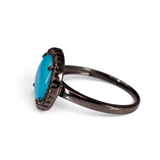 Side view of Sleeping Beauty turquoise CZ halo ring showing slim dark ruthenium band