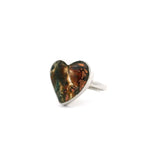 Native copper curved heart cabochon ring with rust and green tones in a simple silver bezel