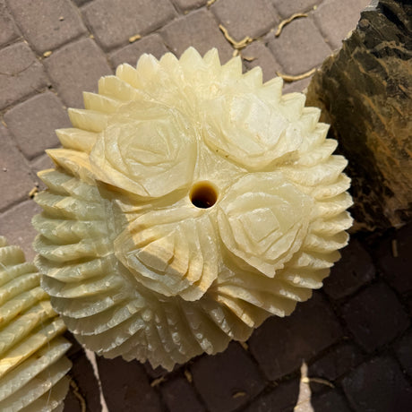 Four carved rose blooms and spiked ribs crowning the barrel cactus onyx fountain