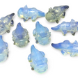Opalite axolotl carvings with milky blue glow, group of ten shown on black surface
