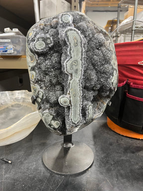 View of Amethyst Druze Geode On Fitted Stand With Polished Agate Stalactite Ridge And Eyes