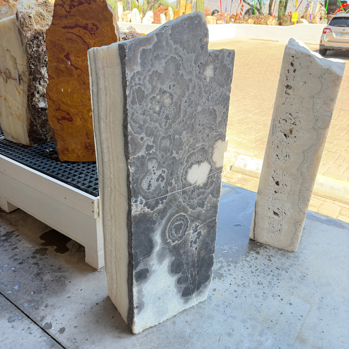 Black and white onyx column fountain with cloudlike black floral patterns on a polished face