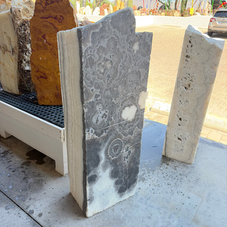 Black and white onyx column fountain with cloudlike black floral patterns on a polished face