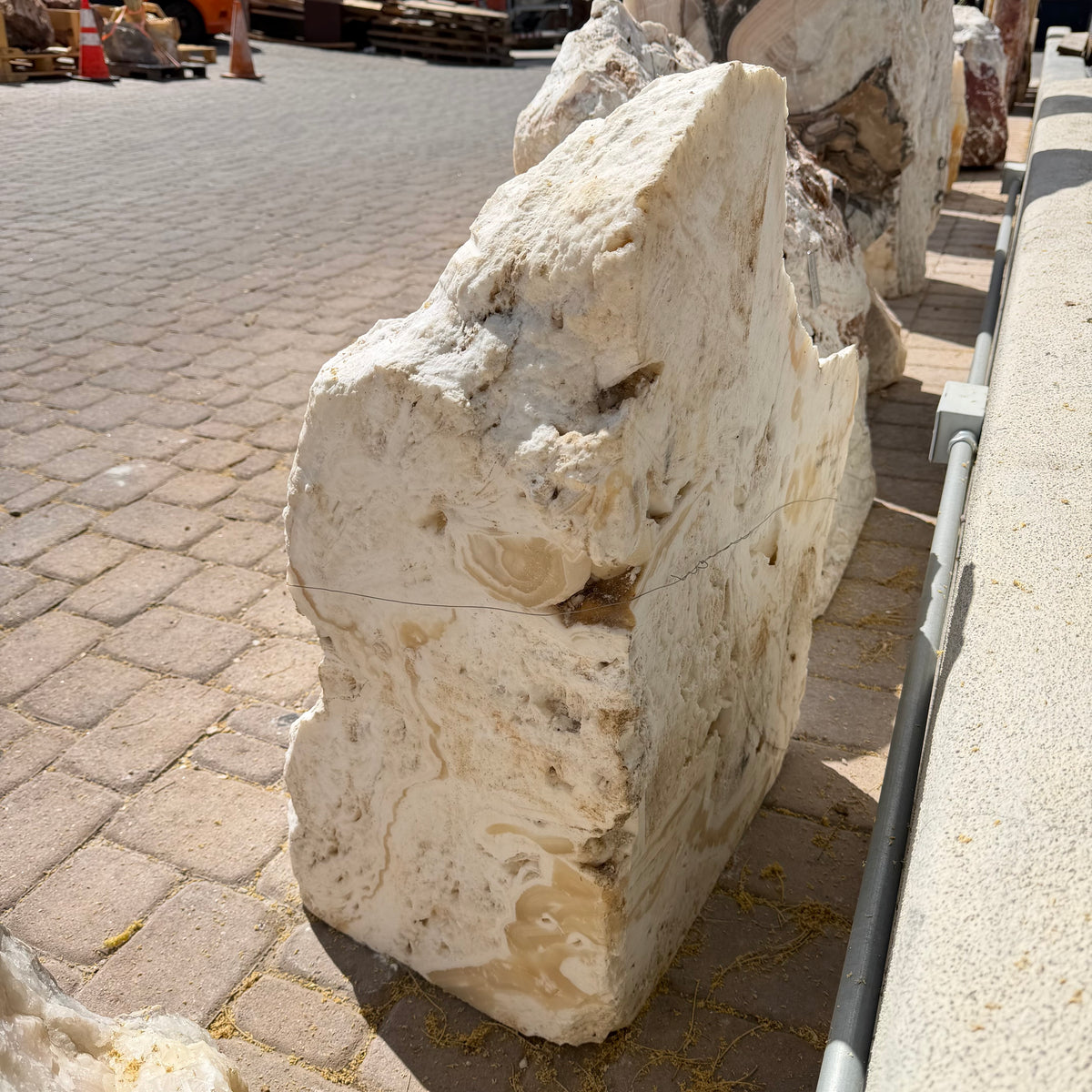 Corner-cut fossil onyx fountain slab seen from the side, showing its thickness and honey-toned banding