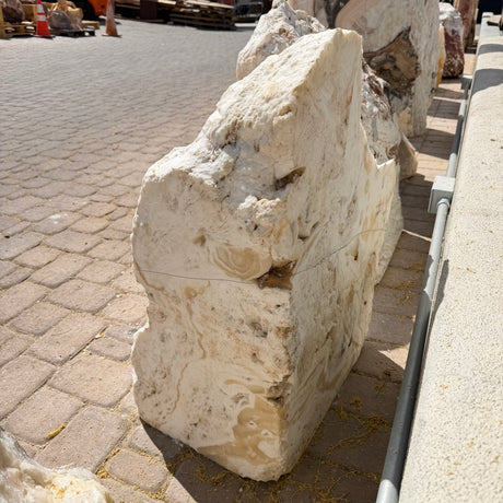 Corner-cut fossil onyx fountain slab seen from the side, showing its thickness and honey-toned banding