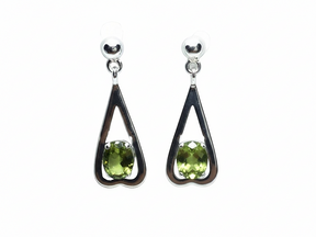 Rare Earth Gallery peridot dangle earrings featuring faceted oval stones in sterling silver reverse heart settings.