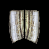 Rare Earth Gallery bookmatched green onyx wall panels with irregular natural borders and translucent veining.