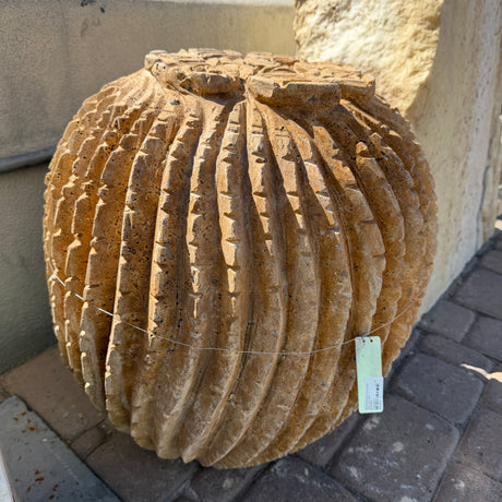 Full round red travertine barrel cactus carving with hanging price tag in the outdoor gallery yard