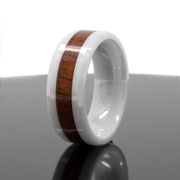 White ceramic ring with Hawaiian koa wood inlay stripe, angled standing view