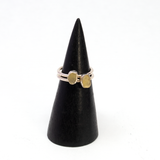 Two Egyptian tektite rings with rough freeform stones in silver bezels shown side by side