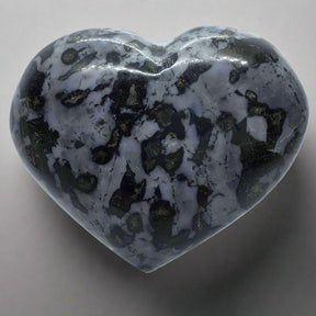 Indigo Gabbro heart with gray and black patterns, displayed on a clear Lucite stand.