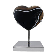 Black agate heart with brown and white banding on chrome stainless steel stand, front view